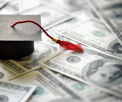 A graduation cap sitting on money.